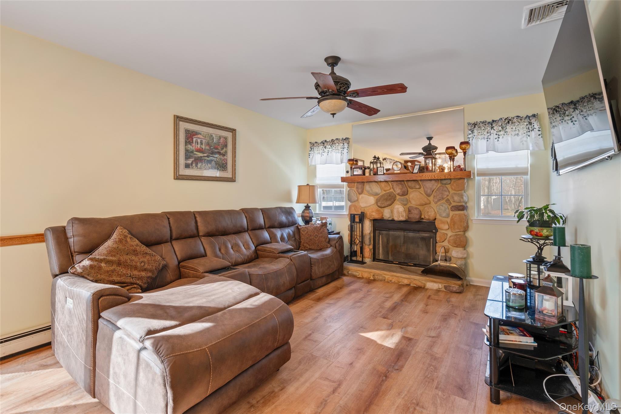 194 Miller Place Road Miller Place, NY 11764 - Photo 16 of 50 a living room with furniture a fireplace and a flat screen tv