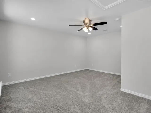 an empty room with a ceiling fan and window