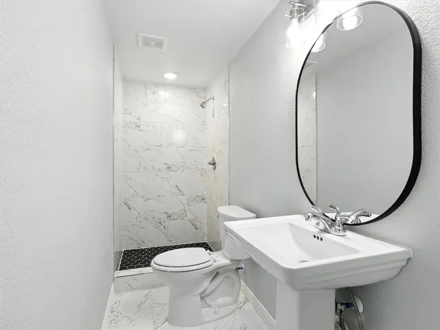 a bathroom with a sink a toilet and a mirror