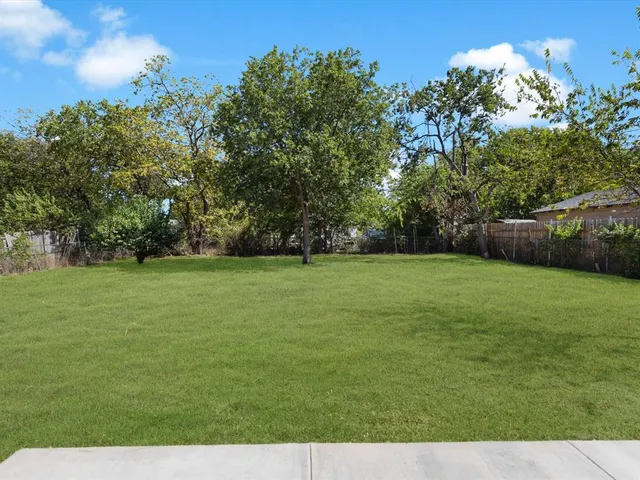 a view of a field of grass and trees