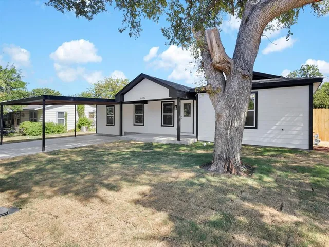 a view of a house with a tree in the yard