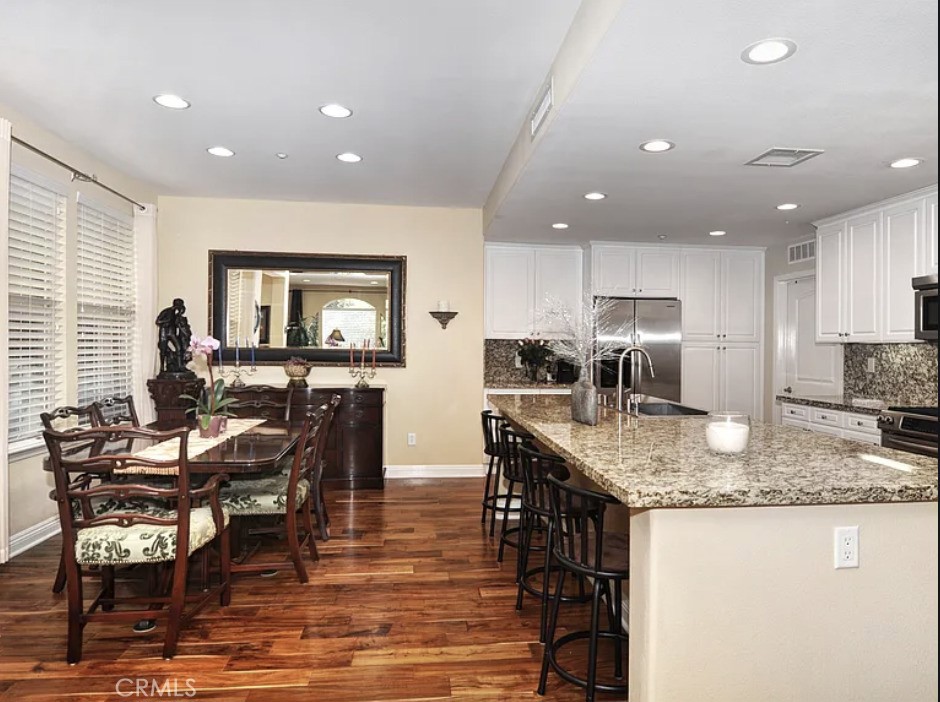 135 Pathway Irvine, CA 92618 - Photo 4 of 12 a kitchen with stainless steel appliances granite countertop dining table chairs and granite counter tops
