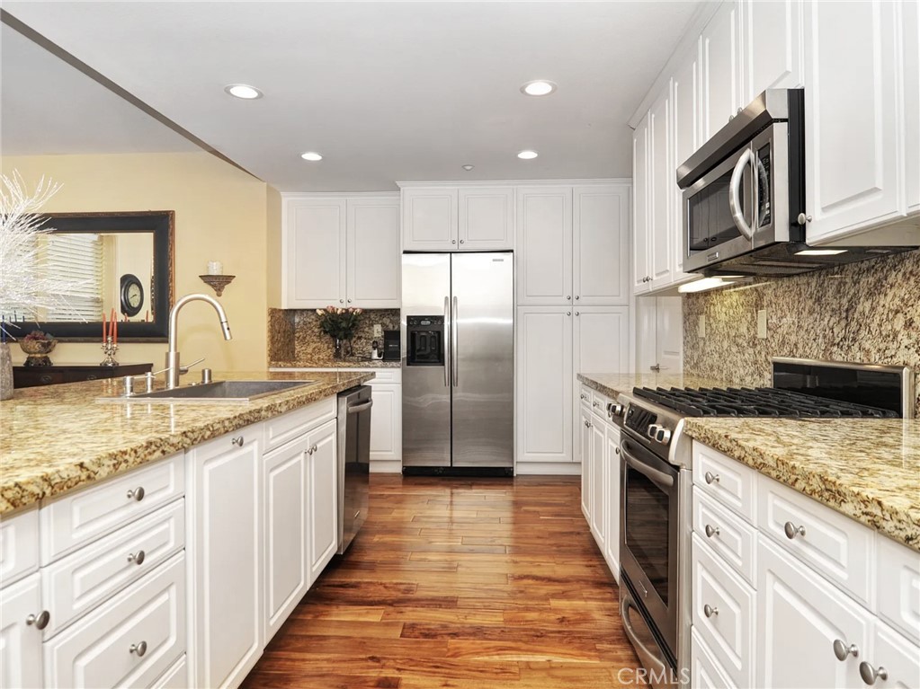 135 Pathway Irvine, CA 92618 - Photo 7 of 12 a kitchen with stainless steel appliances granite countertop a sink stove and refrigerator