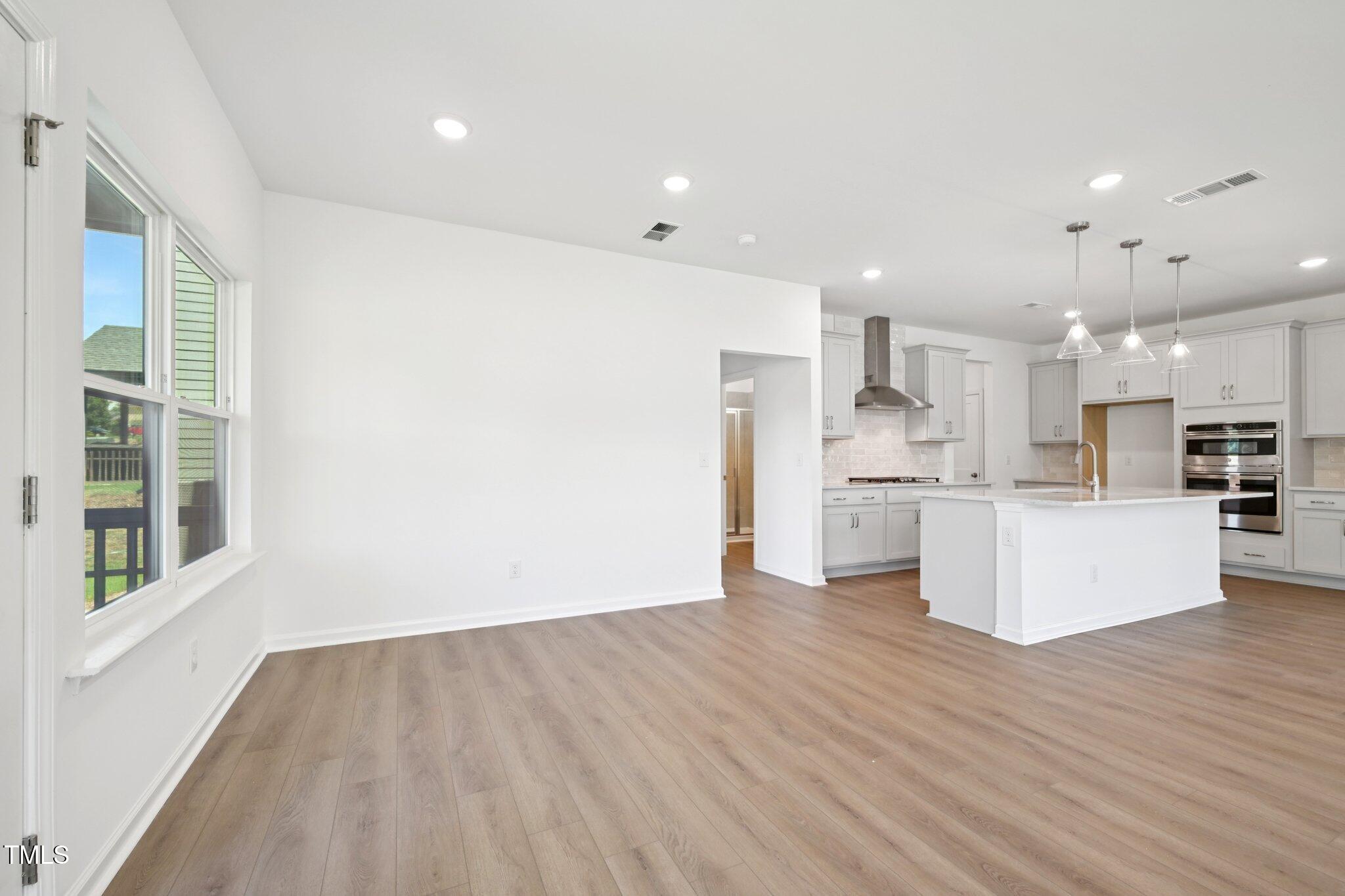 1609 Malcus Court, Unit 67 Fuquay-Varina, NC 27526 - Photo 9 of 40 a view of kitchen with kitchen island white cabinets wooden floor and center island