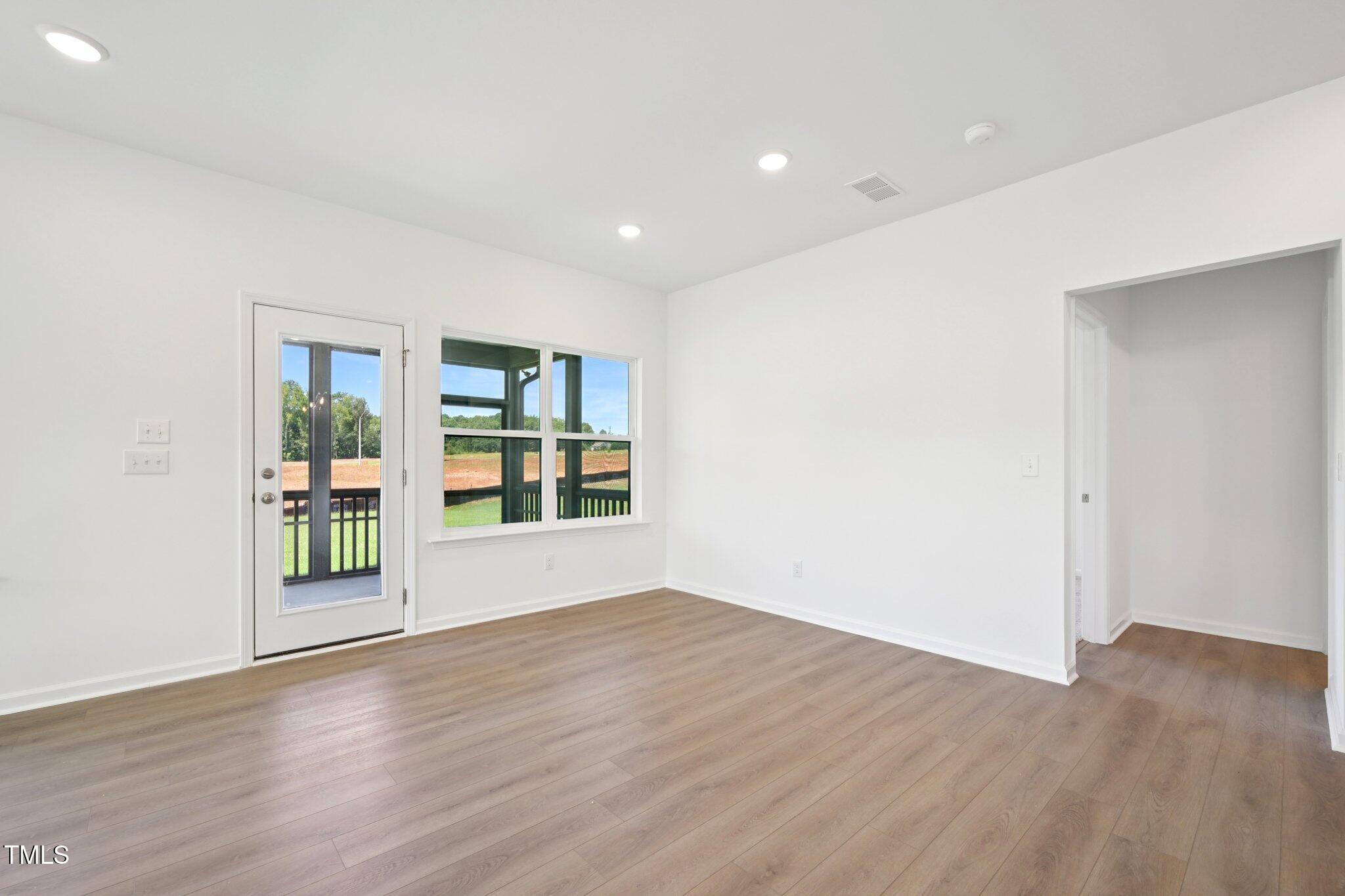 1609 Malcus Court, Unit 67 Fuquay-Varina, NC 27526 - Photo 10 of 40 a view of an empty room with wooden floor and a window
