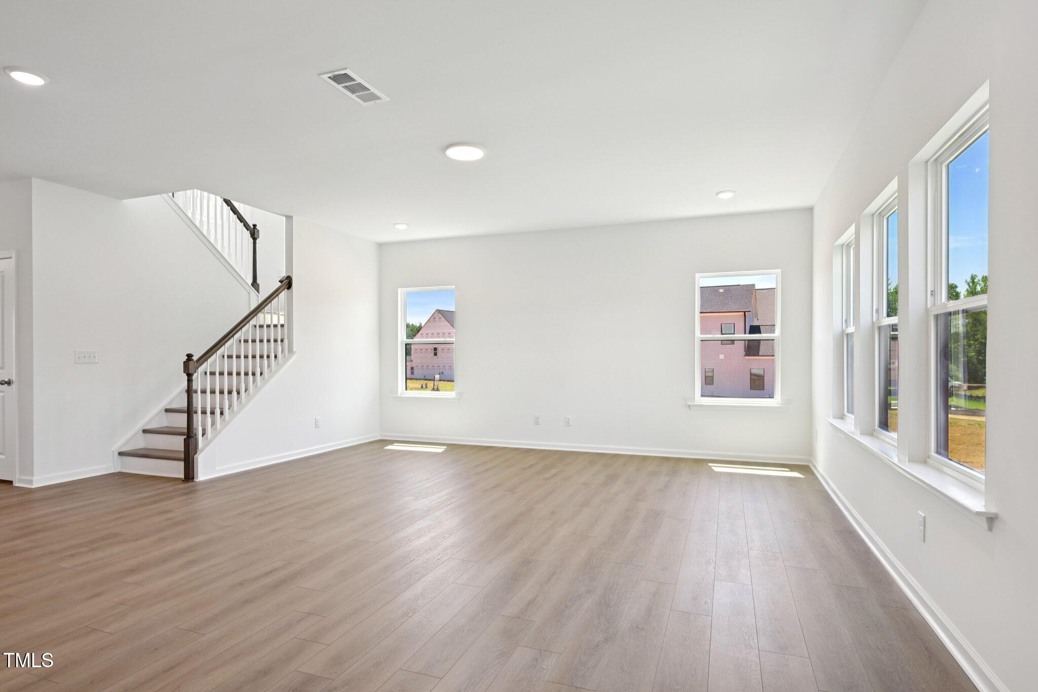 1609 Malcus Court, Unit 67 Fuquay-Varina, NC 27526 - Photo 11 of 40 a view of an empty room with wooden floor and a window
