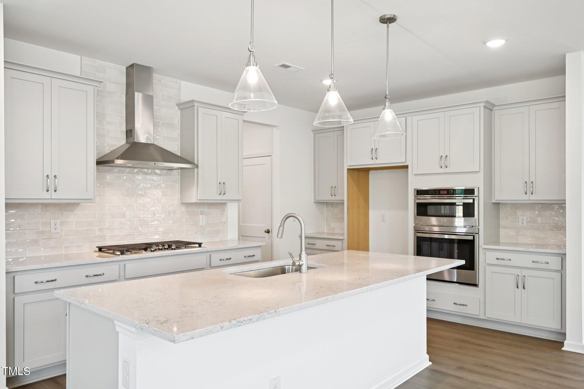 1609 Malcus Court, Unit 67 Fuquay-Varina, NC 27526 - Photo 14 of 40 a kitchen with stainless steel appliances granite countertop a sink a stove a refrigerator and white cabinets