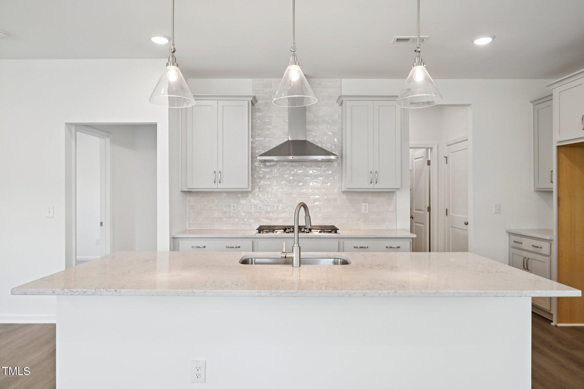 1609 Malcus Court, Unit 67 Fuquay-Varina, NC 27526 - Photo 15 of 40 a kitchen with kitchen island a counter top space a sink stainless steel appliances and cabinets