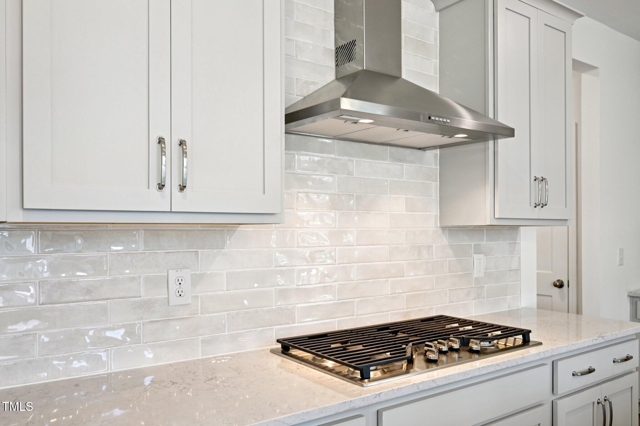 1609 Malcus Court, Unit 67 Fuquay-Varina, NC 27526 - Photo 16 of 40 a kitchen with a stove and a white cabinet
