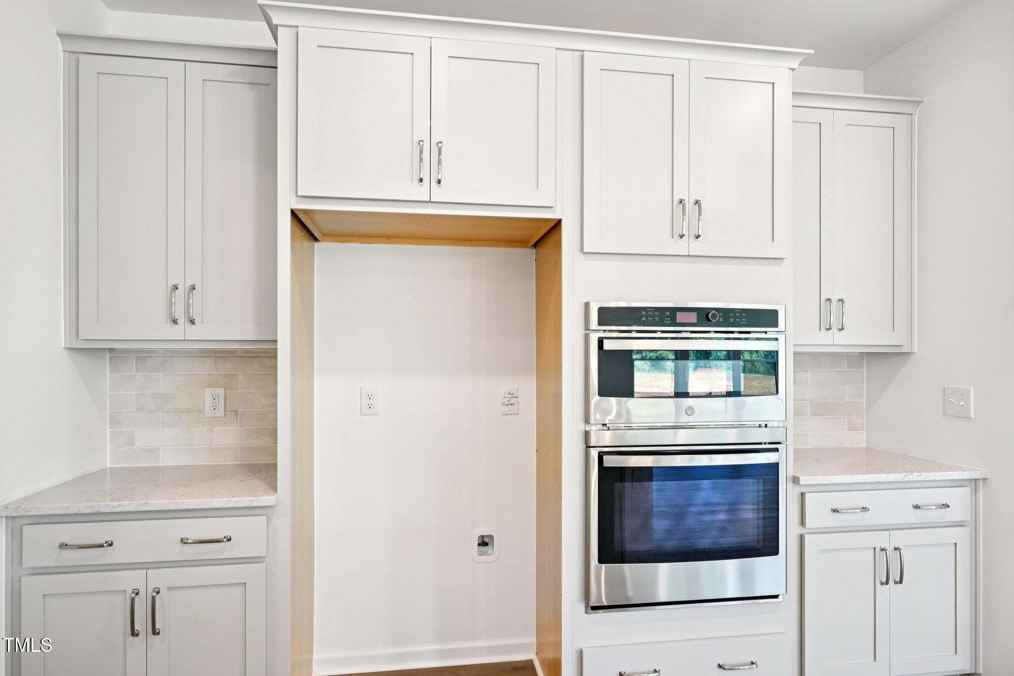 1609 Malcus Court, Unit 67 Fuquay-Varina, NC 27526 - Photo 17 of 40 a view of kitchen with white cabinets and a refrigerator