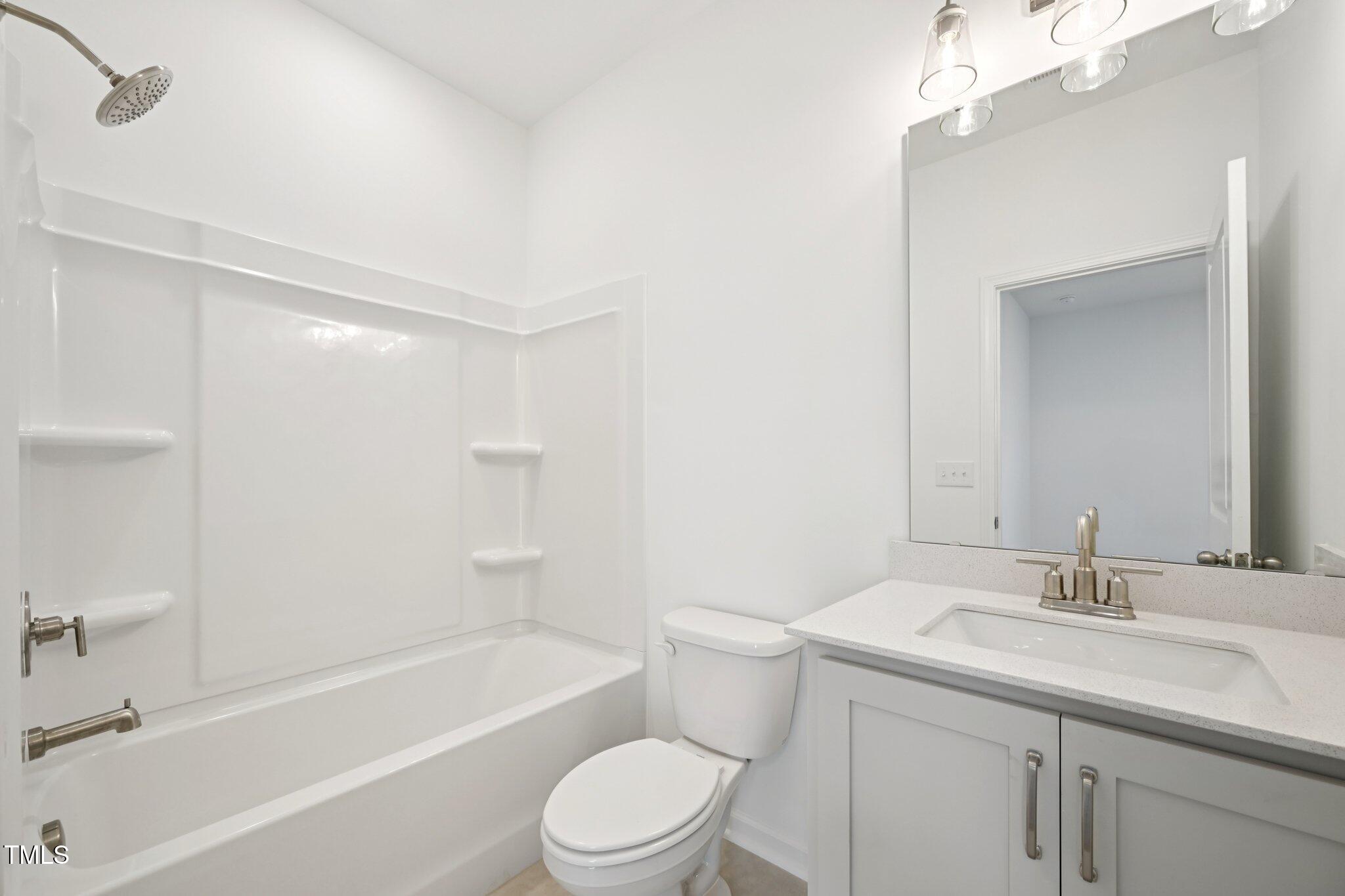 1609 Malcus Court, Unit 67 Fuquay-Varina, NC 27526 - Photo 30 of 40 a bathroom with a sink a toilet and shower