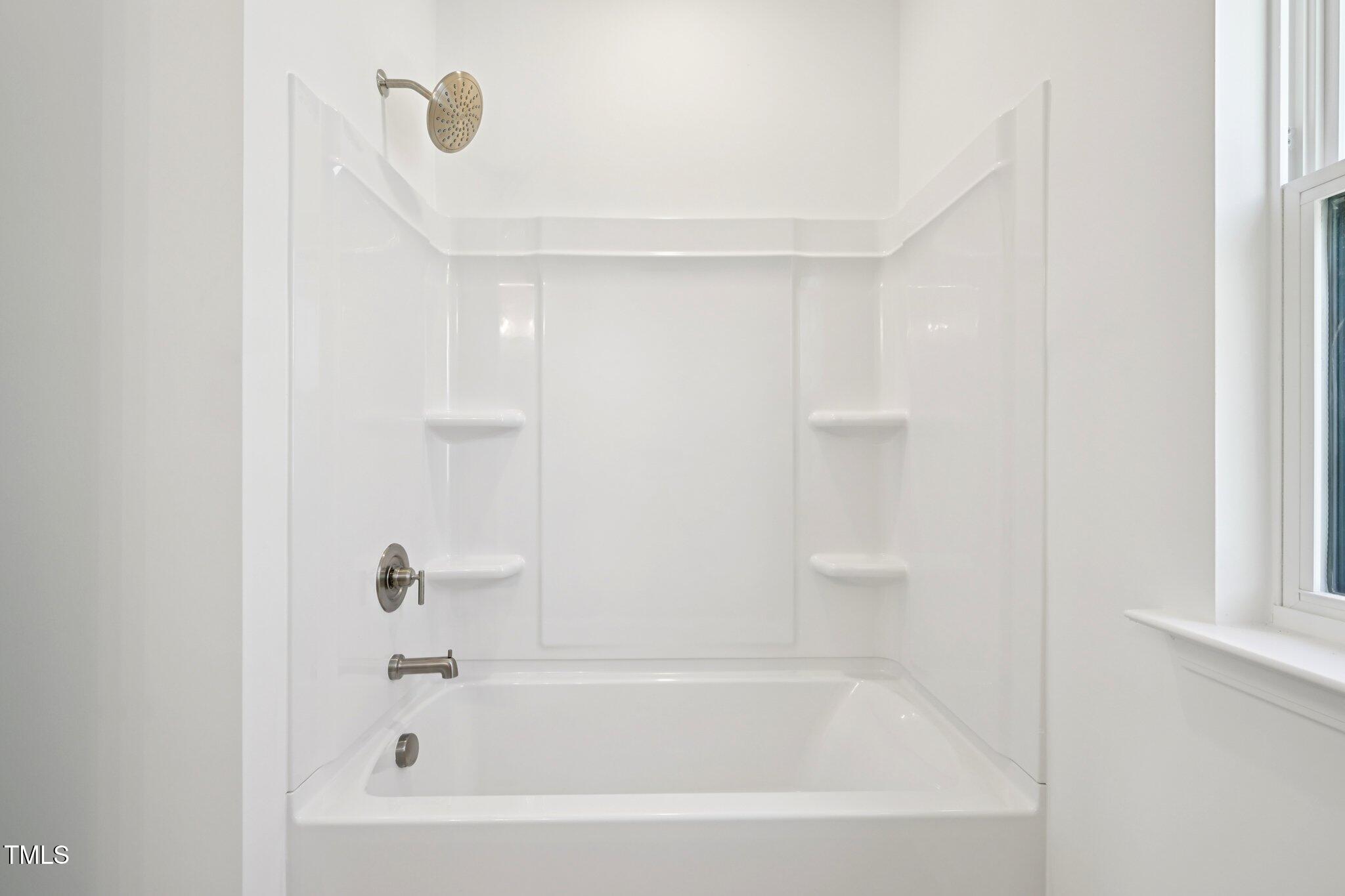 1609 Malcus Court, Unit 67 Fuquay-Varina, NC 27526 - Photo 32 of 40 a white bath tub sitting next to a white sink and vanity