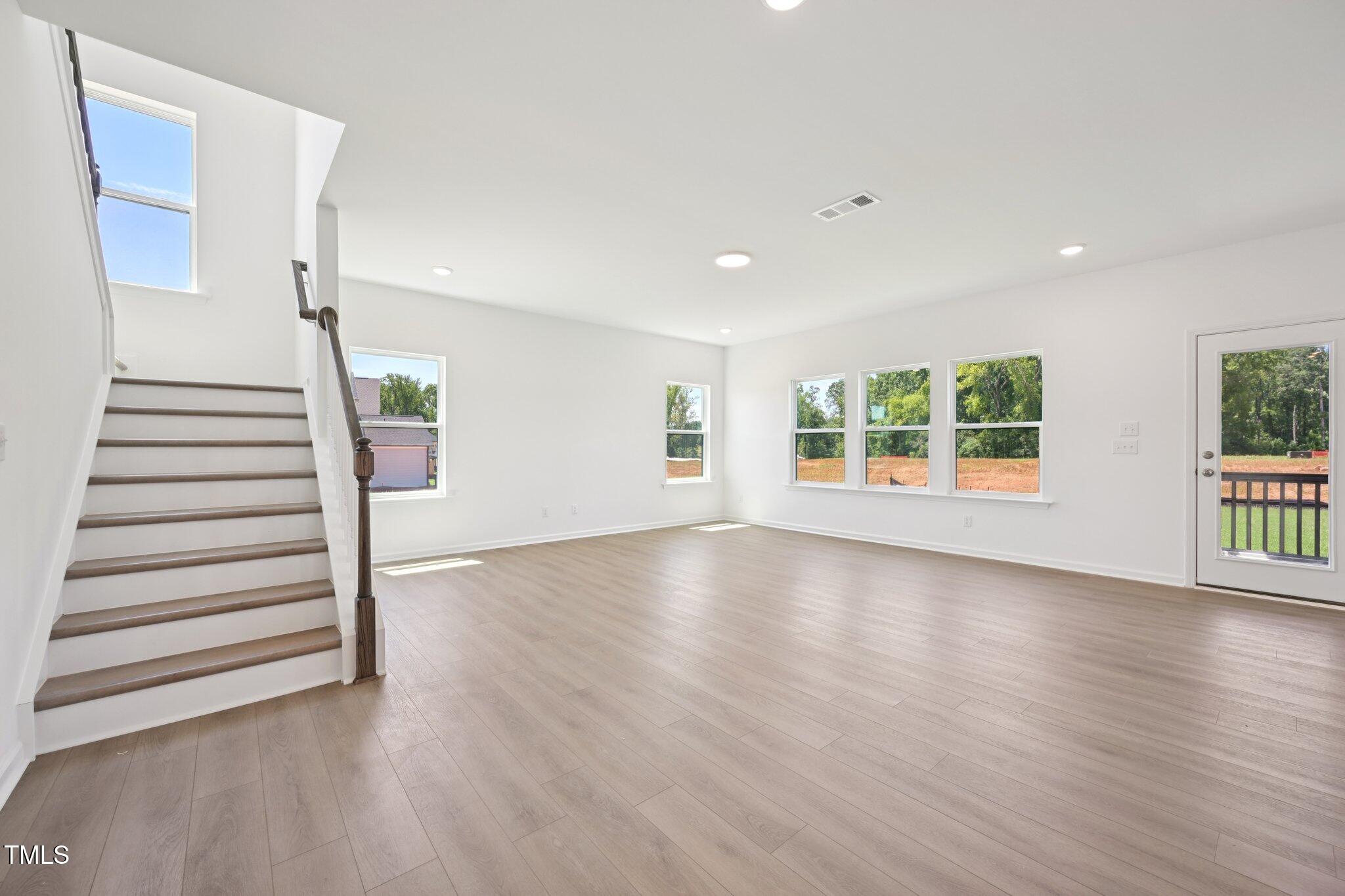 1609 Malcus Court, Unit 67 Fuquay-Varina, NC 27526 - Photo 8 of 40 an empty room with wooden floor and windows