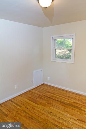 12407 Denley Road Silver Spring, MD 20906 - Photo 14 of 30 a view of an empty room with wooden floor and a window