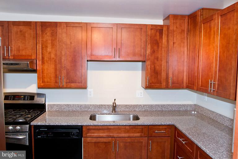 12407 Denley Road Silver Spring, MD 20906 - Photo 7 of 30 a kitchen with stainless steel appliances granite countertop a sink a stove and a microwave
