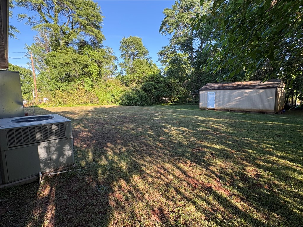 103 Elm Avenue Anderson, SC 29625 - Photo 2 of 19 Expansive green lawn with a practical storage shed, ideal for outdoor living.