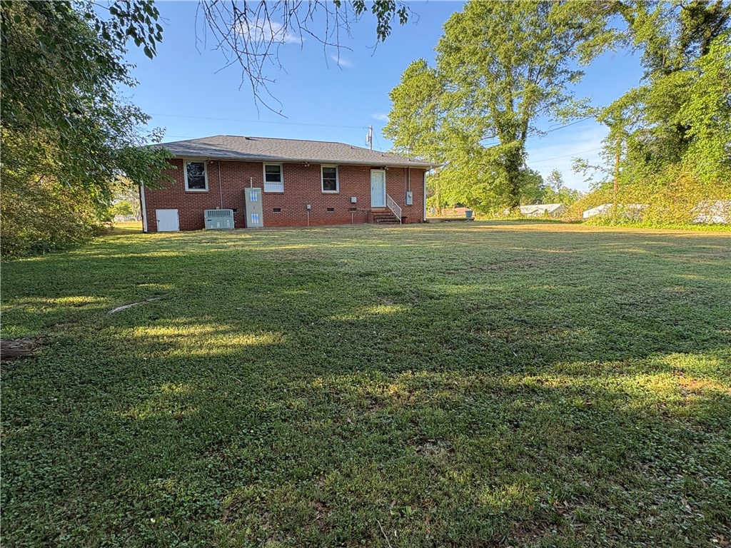 103 Elm Avenue Anderson, SC 29625 - Photo 3 of 19 Expansive green space surrounds this classic brick residence, offering ample outdoor living.