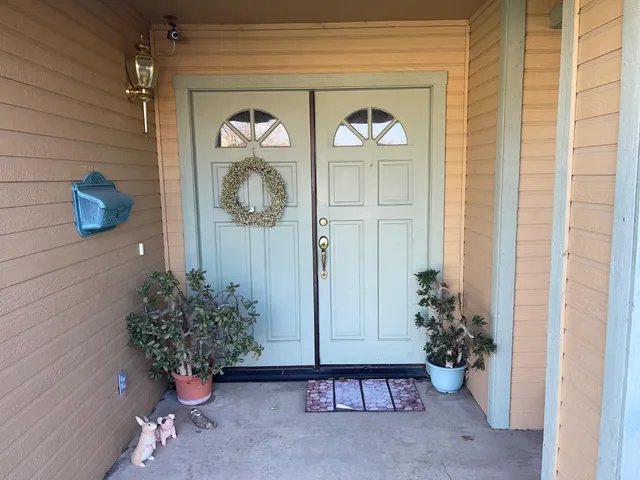 a vase with flowers sitting on a floor in front of a door