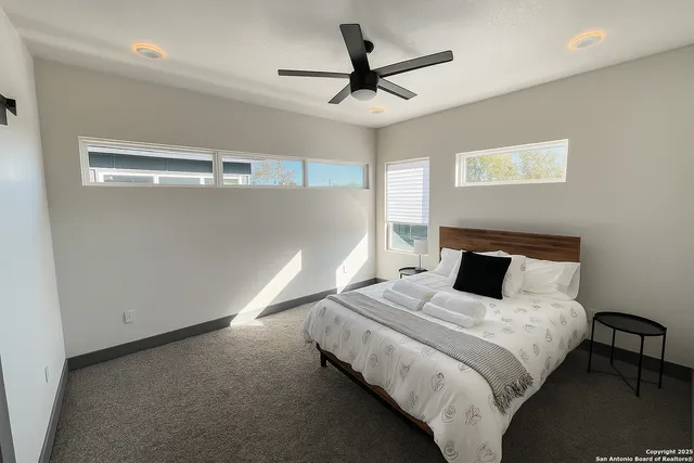 a bedroom with a bed and a ceiling fan