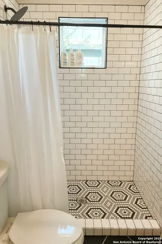 a bathroom with a toilet and a shower curtain