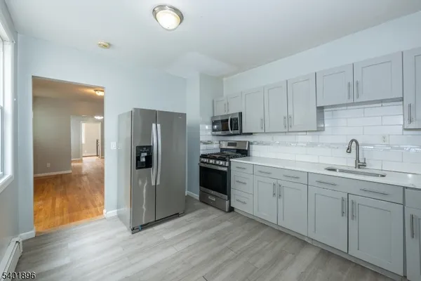 a kitchen with a refrigerator sink and cabinets