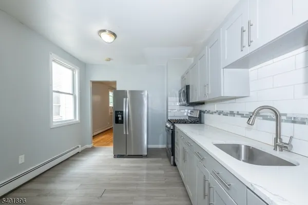 a kitchen with stainless steel appliances granite countertop a sink and a refrigerator