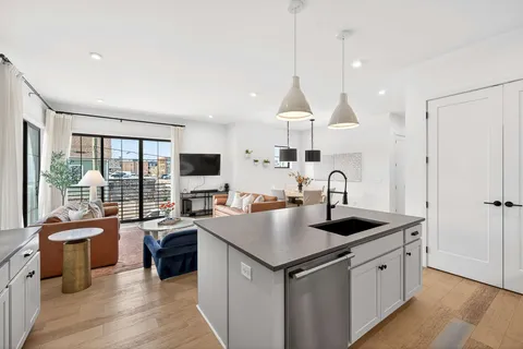 a kitchen with stainless steel appliances granite countertop a sink a stove and a refrigerator