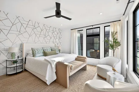 a spacious bedroom with a bed and glass window