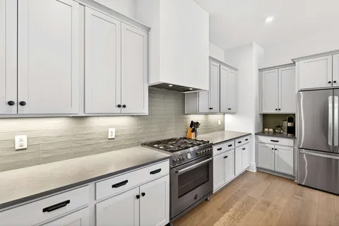 a kitchen with granite countertop a sink stainless steel appliances and cabinets