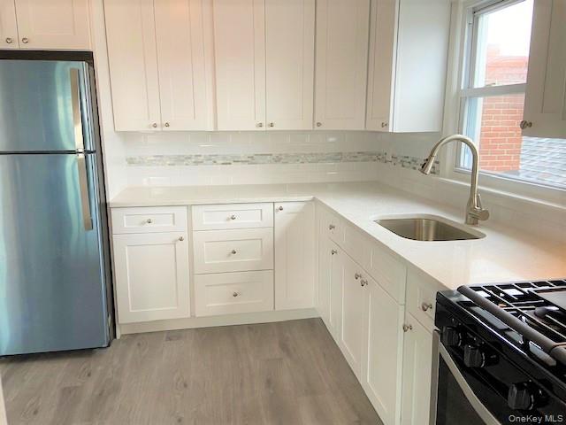 77 Kentucky Street, Unit UPPR Long Beach, NY 11561 - Photo 3 of 15 a kitchen with granite countertop a sink stove and refrigerator