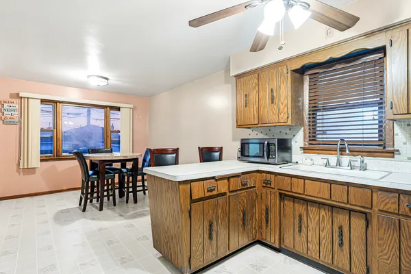 a kitchen that has a sink a table and chairs in it