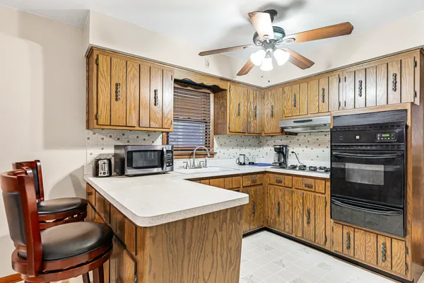 a kitchen with a stove a sink and cabinets