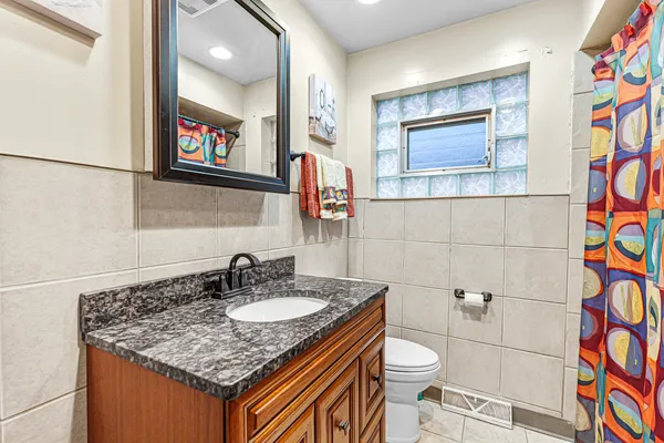 a bathroom with a granite countertop sink and a mirror