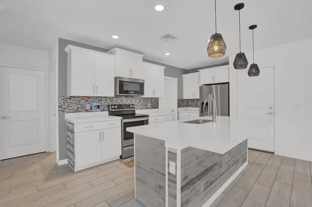 a kitchen with white cabinets and stainless steel appliances