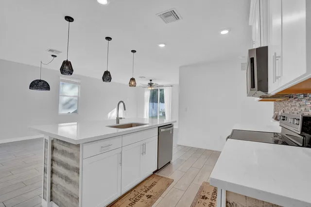 a kitchen with granite countertop a sink a stove and a refrigerator