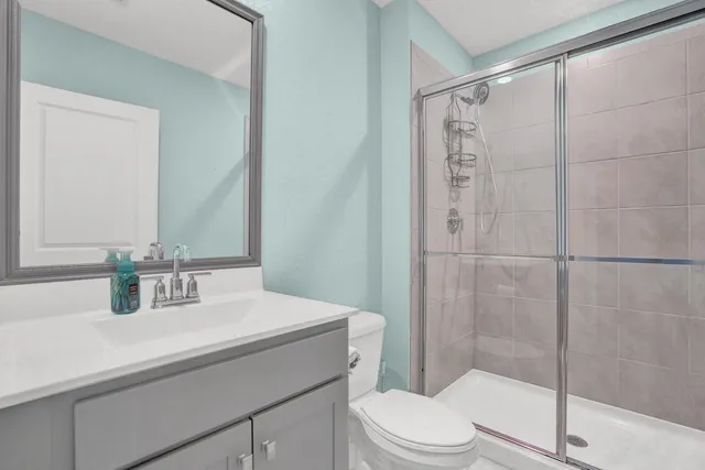 a bathroom with a sink a toilet and shower