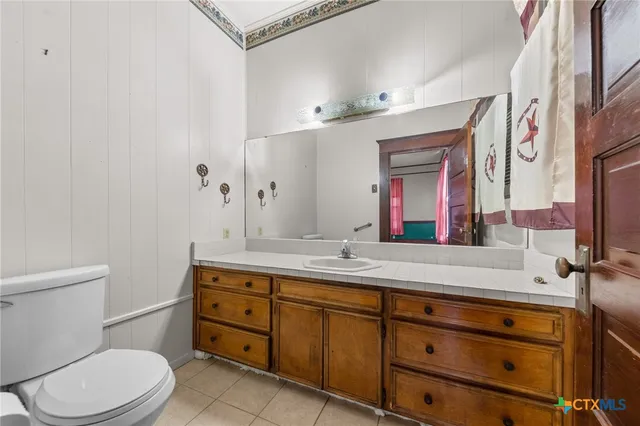 a bathroom with a toilet sink and mirror