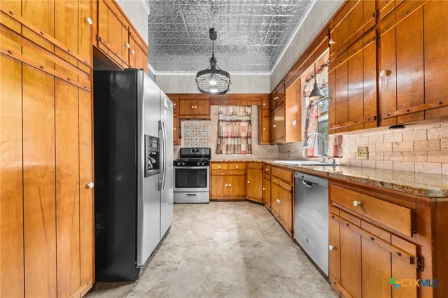a kitchen with stainless steel appliances granite countertop a sink and a stove
