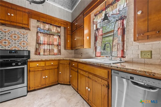 a kitchen with stainless steel appliances granite countertop a stove and a refrigerator