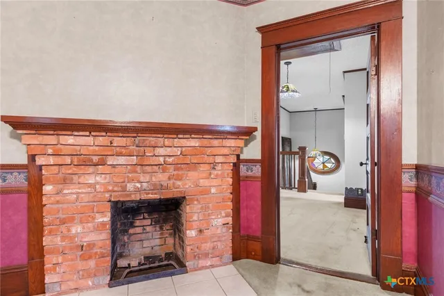 a view of an empty room with window and fireplace