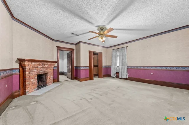 an empty room with windows and a ceiling fan