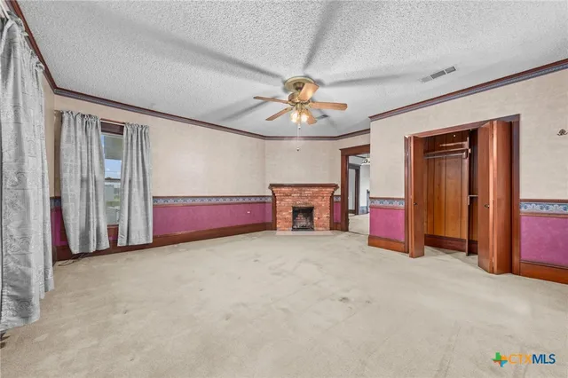 a view of an empty room with a ceiling fan