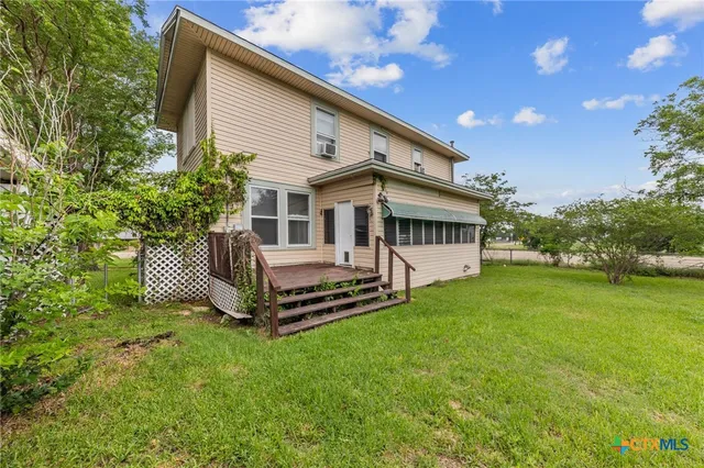 a view of a house with a yard and sitting area