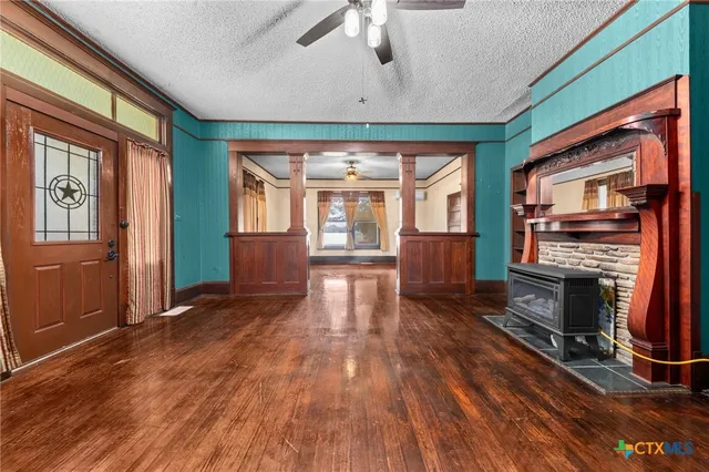 wooden floor fireplace and windows in an empty room