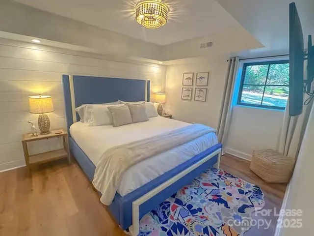 a bedroom with a bed and a lamp on dresser