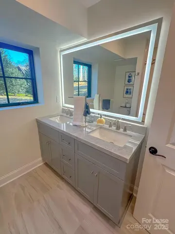 a bathroom with a granite countertop sink a mirror and a window