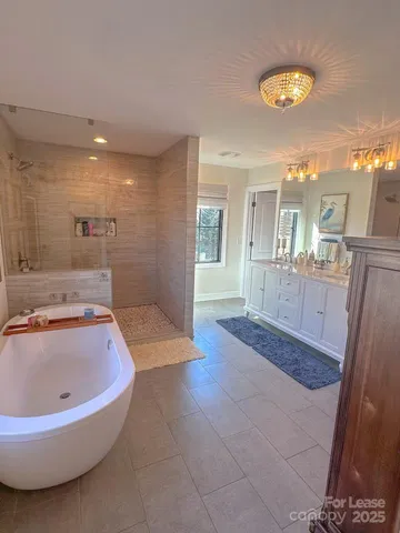 a bathroom with a tub sink and mirror