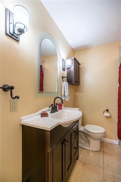 105 Deer Road Pittsburgh, PA 15237 - Photo 15 of 25 Just across the hall from the first floor master bedroom sits this full bathroom with tile flooring, newer vanity, sconces and tiled surround shower.