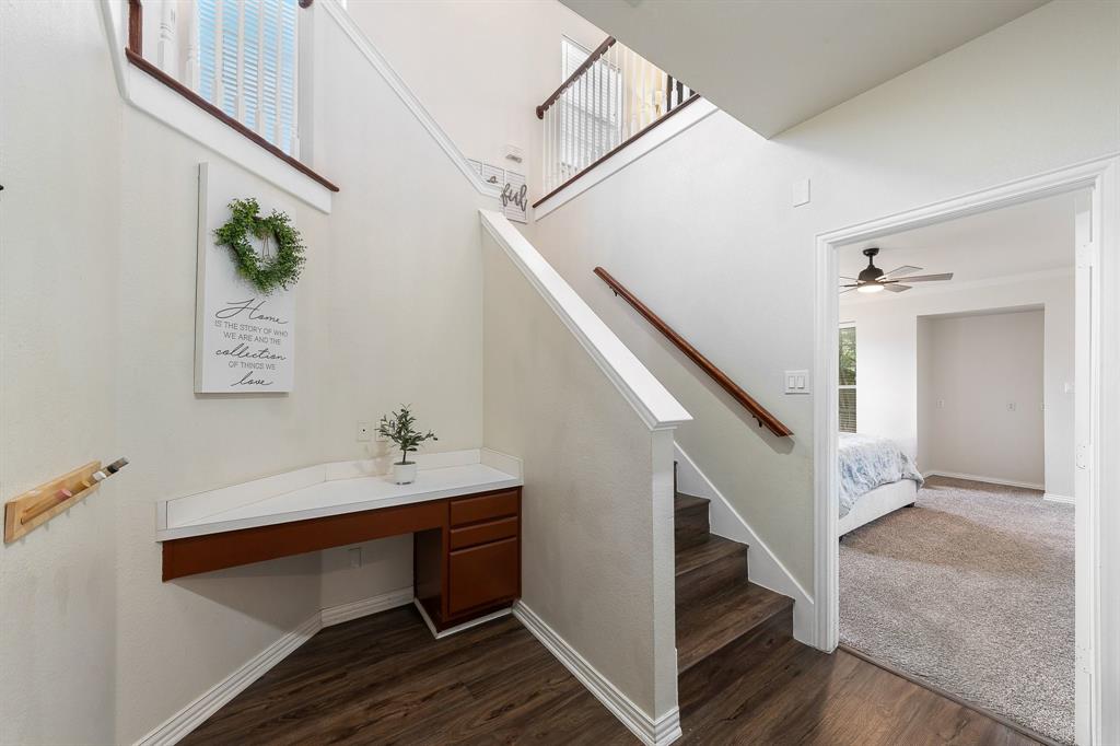 18240 Midway Road, Unit 1301 Dallas, TX 75287 - Photo 20 of 25 Staircase with wood-finish treads and handrail, featuring a built-in desk with a light-colored countertop and wood-finish cabinetry