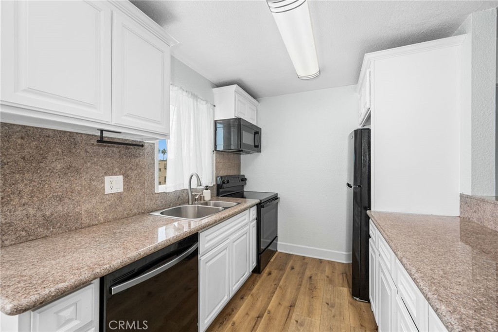 3142 Midway Drive, Unit B307 San Diego, CA 92110 - Photo 2 of 17 a kitchen with a sink and a refrigerator
